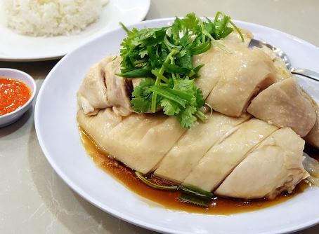 Sliced poached chicken with coriander, sauce, and rice